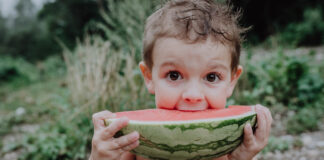 Kind isst Wassermelone für Familienfotos