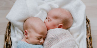 Neugeborene Zwillinge in Weidenkörbchen